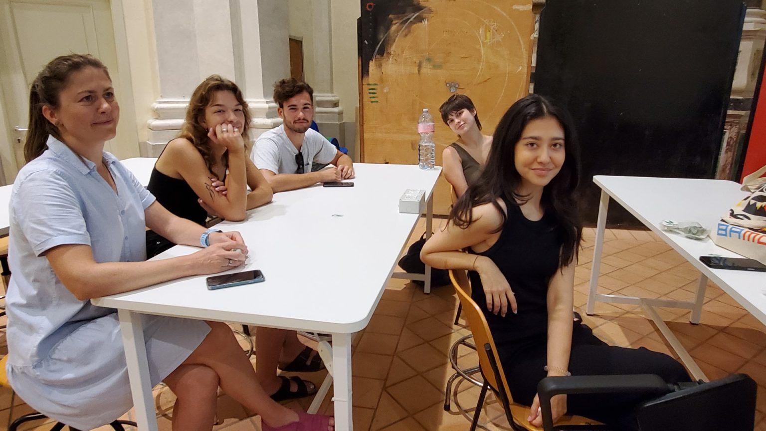 Student i 4 studentki pozują do zdjęcia na sali wykładowej