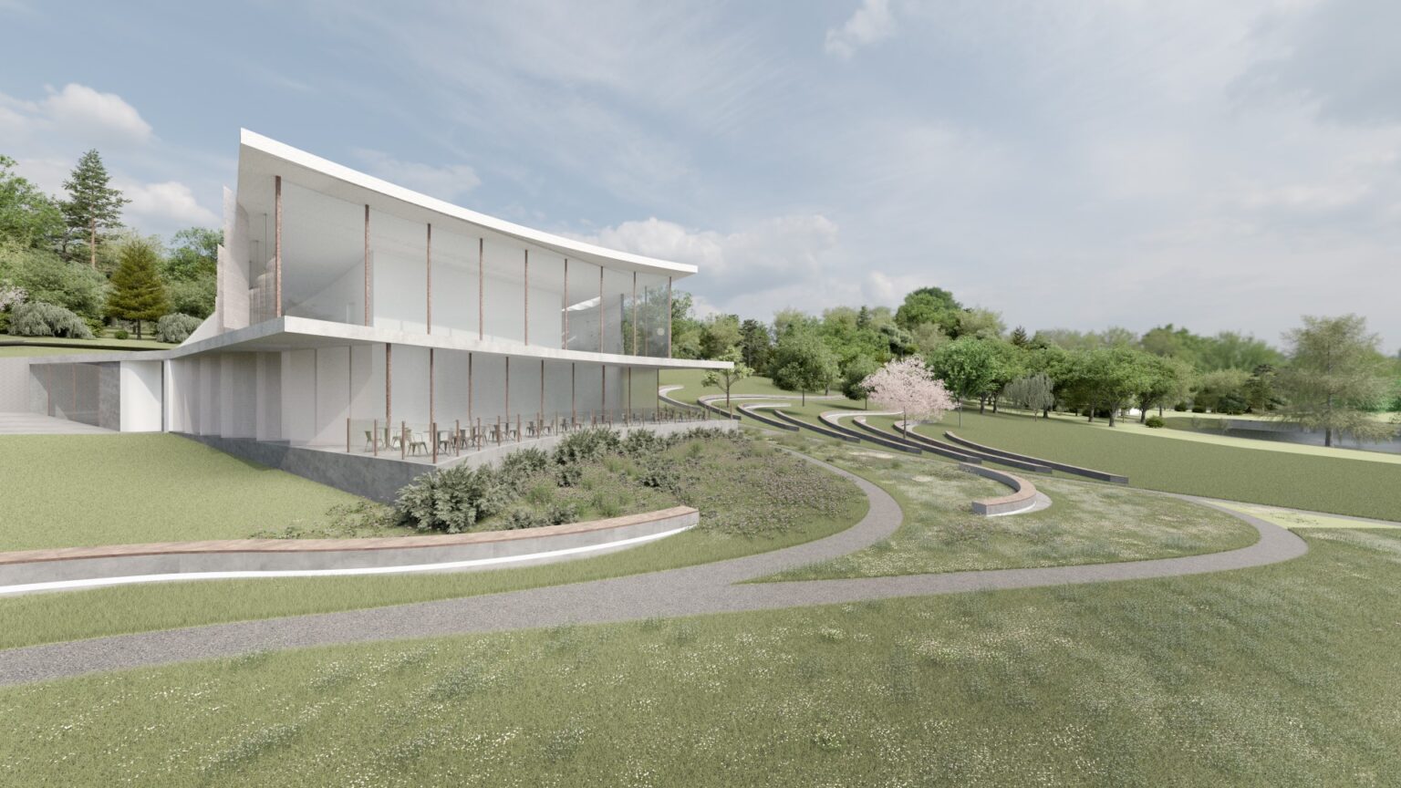 nowoczesny, przeszklony budynek restauracji z lekkim, falistym dachem, otoczony parkowym krajobrazem. Wokół znajdują się kręte ścieżki, tarasy z roślinnością i półokrągłe ławki. Budynek harmonijnie wpisuje się w naturalne otoczenie.