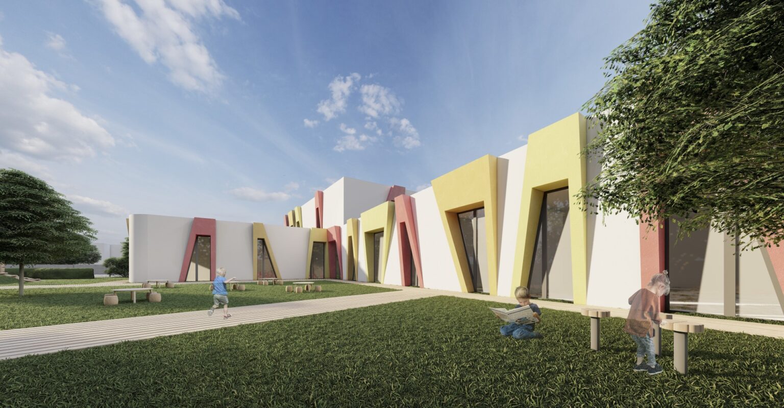 kolorowy, nowoczesny budynek przedszkola otoczony zielenią. Elewacja ma dynamiczny design z asymetrycznymi, wystającymi elementami w kolorach żółtym, czerwonym i białym. Na trawie bawią się dzieci, tworząc atmosferę przestrzeni edukacyjnej lub rekreacyjnej.